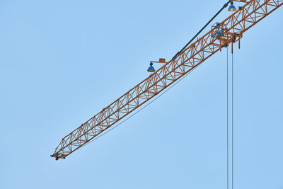 Low angle view of crane against sky