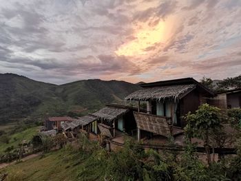Houses on mountain against sky during sunset