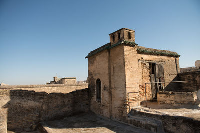 Low angle view of old ruins against clear blue sky