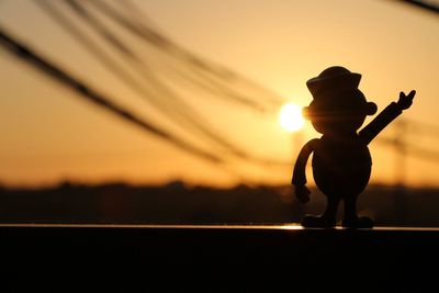 Close-up of silhouette child against sky during sunset