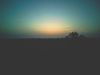 Scenic view of silhouette field against clear sky during sunset