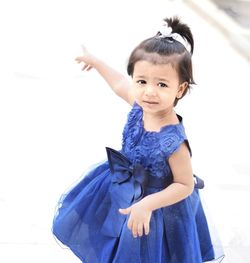 Portrait of happy girl standing against white background