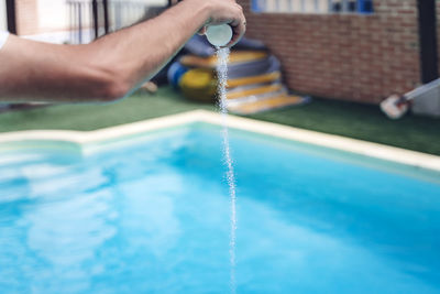 Midsection of person playing in swimming pool