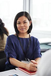 Portrait of young businesswoman sitting at desk