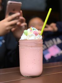 Close-up of hand holding drink served on table