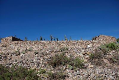 Panoramic view of field against clear blue sky