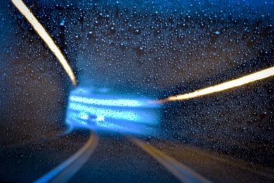 Close-up of waterdrops on glass against road