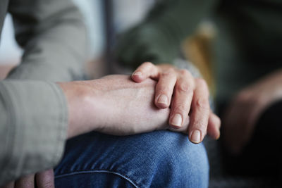 Close-up of man and woman touching hands