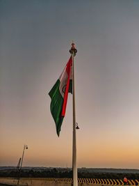 Low angle view of flag against sky during sunset