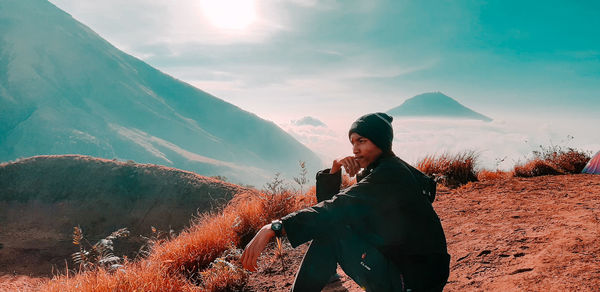 Young woman on mountain against sky during winter