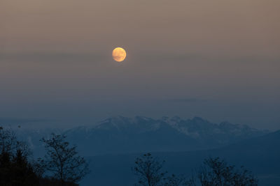 Scenic view of snowcapped mountains against sky at sunset