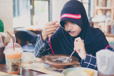 Girl eating food at restaurant table