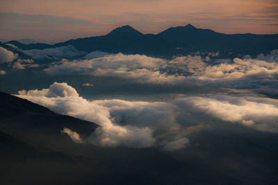 Scenic view of cloudscape against mountains during sunset