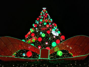Illuminated christmas tree against sky at night