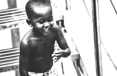 Portrait of happy boy standing against water