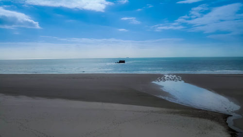 Scenic view of sea against cloudy sky