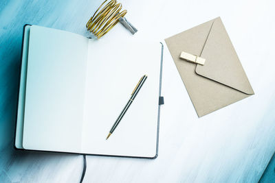 High angle view of blank book with pen on table