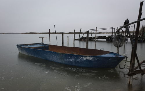 Boat moored on sea against sky