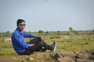 Young man sitting on field