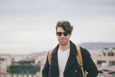 Portrait of man wearing sunglasses against cityscape