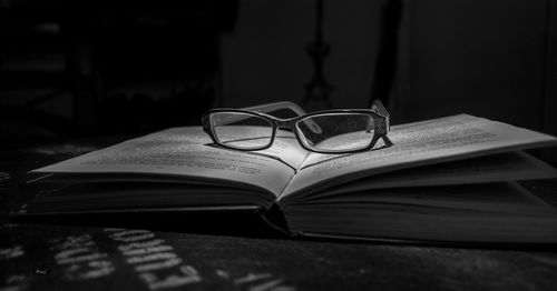 Close-up of eyeglasses on book in darkroom