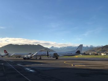 Airplane on airport runway against sky