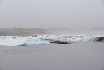 Idyllic shot of glacier in foggy weather against sky