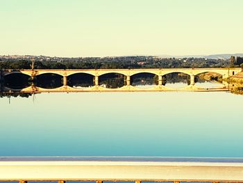 Arch bridge over river against sky