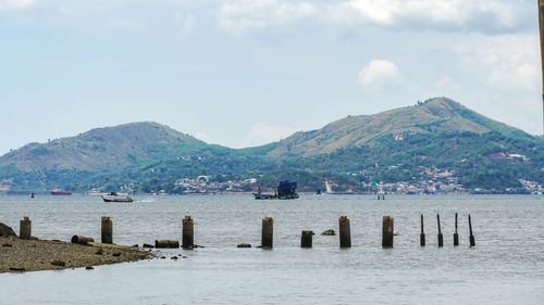 Scenic view of sea and mountains against sky