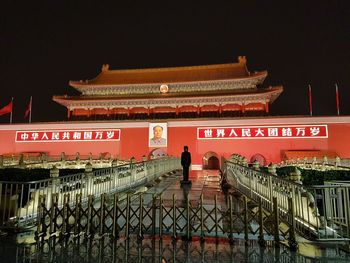 Illuminated building in city against sky at night