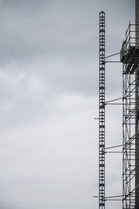 Low angle view of crane against sky