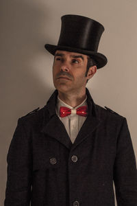 Portrait of man wearing hat against gray background