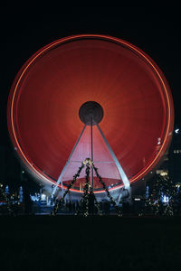 Low angle view of illuminated ferris wheel against sky at night