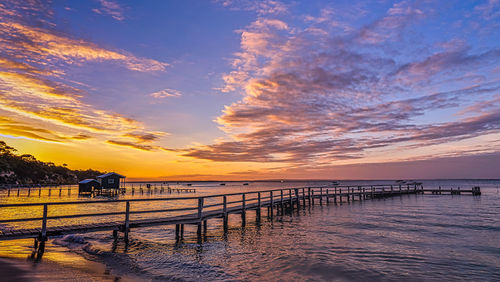 Pier over sea against sky during sunset