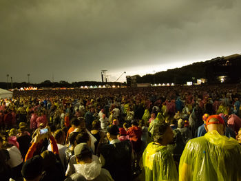 Crowd at music concert against sky