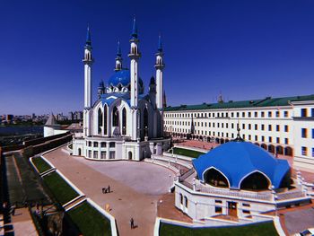 View of buildings in city against clear blue sky