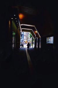 People walking on illuminated footpath at night