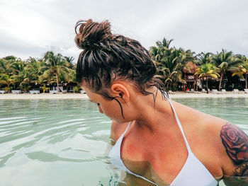 Portrait of young woman in swimming pool against sky