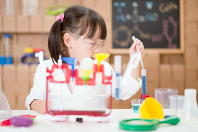 Young girl playing science experiment at home 