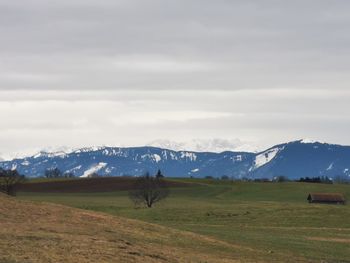 Scenic view of field and mountains against sky