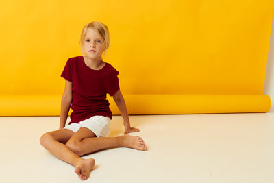 Full length of young woman exercising against wall