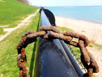 Close-up of rusty chain on sea shore