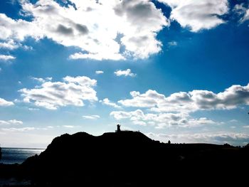 Scenic view of silhouette by sea against sky