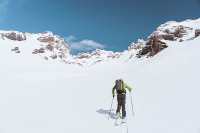 Athlete skinning towards mountains during sunny day