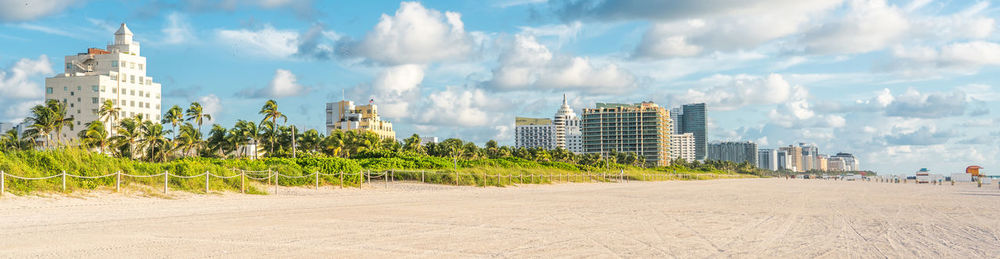 Panoramic view of buildings against cloudy sky