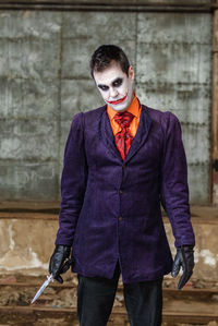 Portrait of young man standing against wall