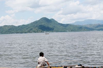 Men on boat in sea against sky