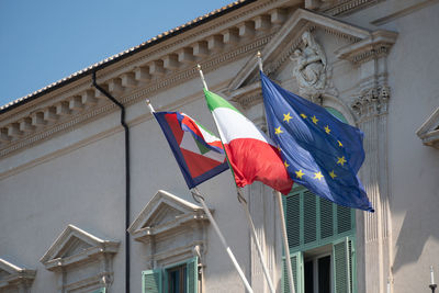 European and italian flags and italian presidential pennant outside quirinale palace, rome