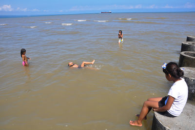 People at beach against sky