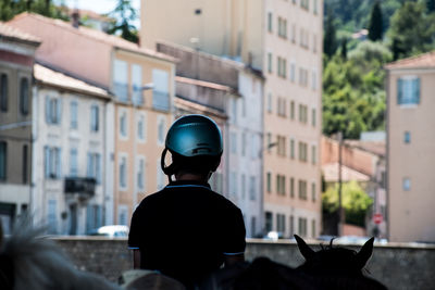 Rear view of man standing on street against buildings